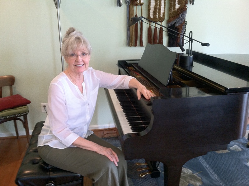 Meldene Gruber sits behind a grand piano in her Rehoboth Beach home. BY KARA NUZBACK